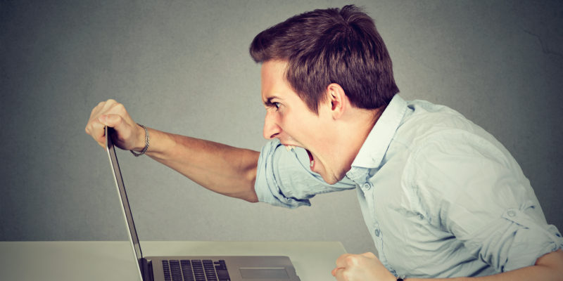Entrepreneur angry and furious with a laptop in his office or home